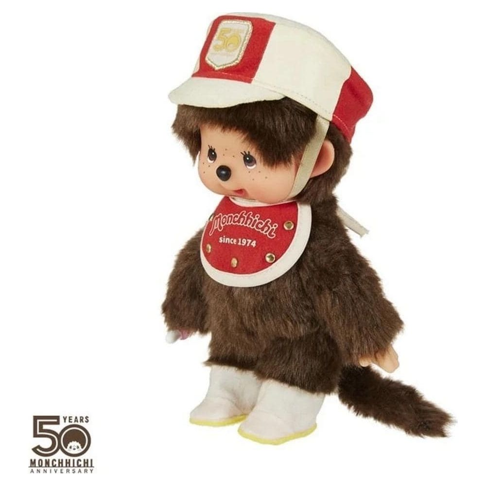 Un Monchhichi con bavaglino rosso, cappellino bianco-rosso e logo 50.