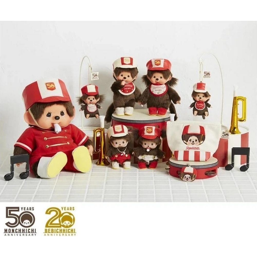 Bambole Monchhichi in divise e cappelli rossi, alcune con bavaglini.