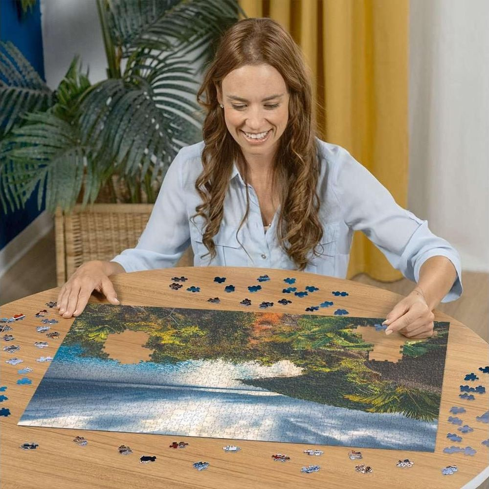 Donna che assembla un puzzle di alberi riflessi in un lago.