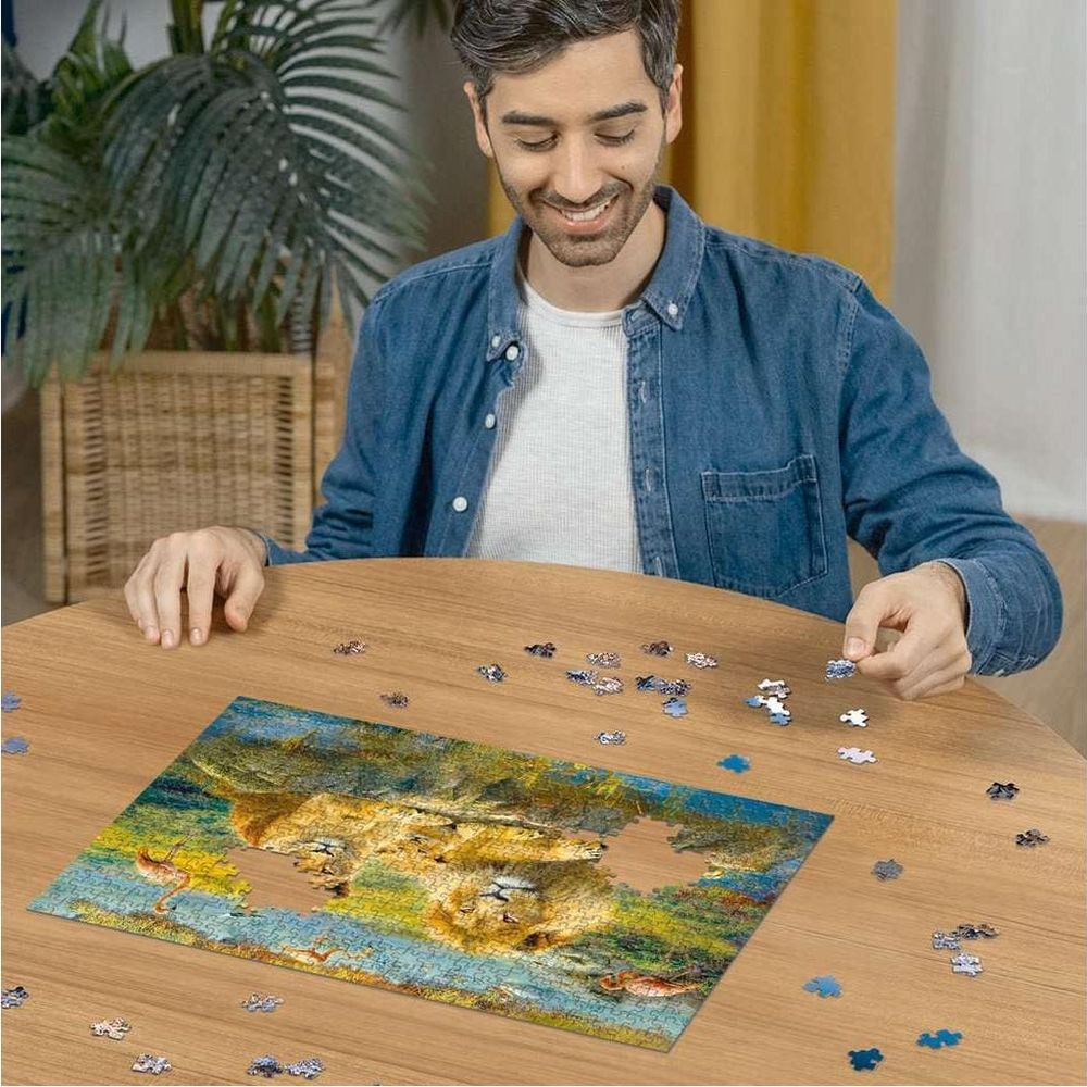 Mann setzt ein Löwenpuzzle auf einem Holztisch zusammen. Verstreute Puzzleteile umgeben das Hauptbild.