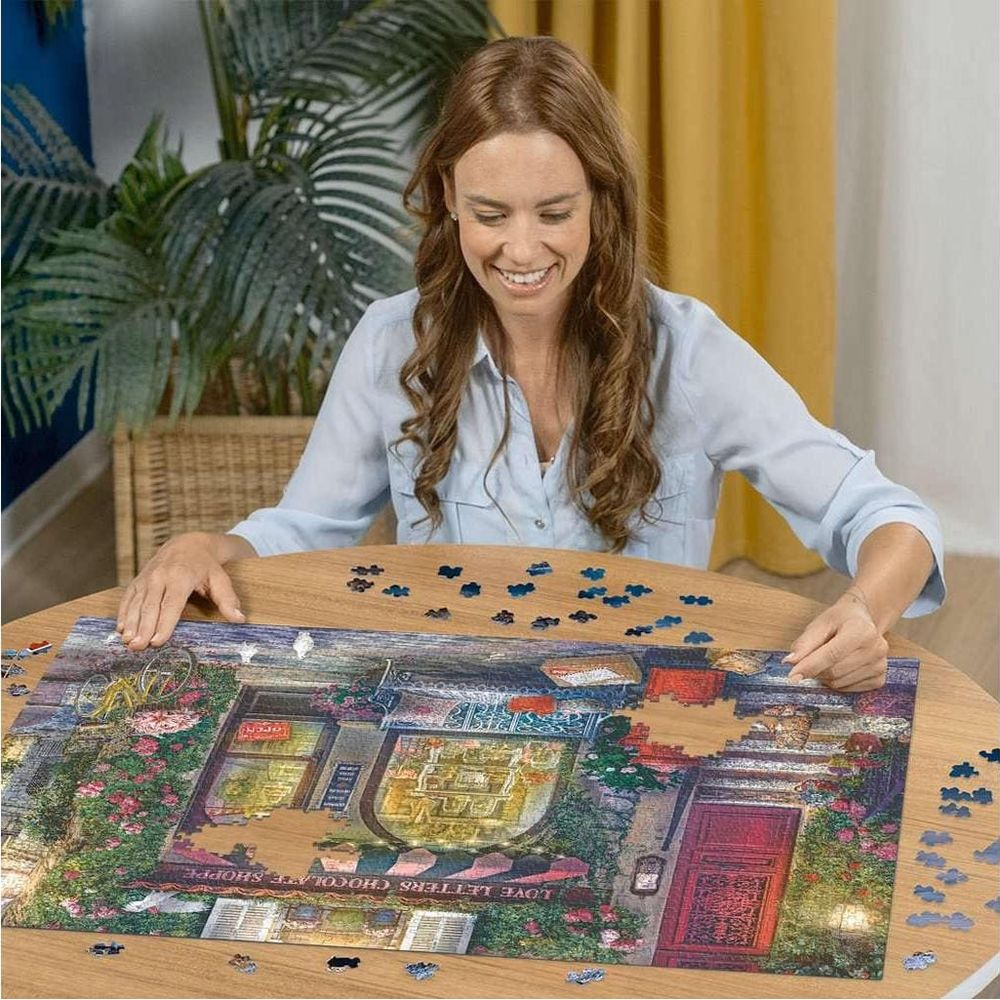 Frau puzzelt ein Bild eines Schokoladengeschäfts mit Rosen und einem roten Tor.