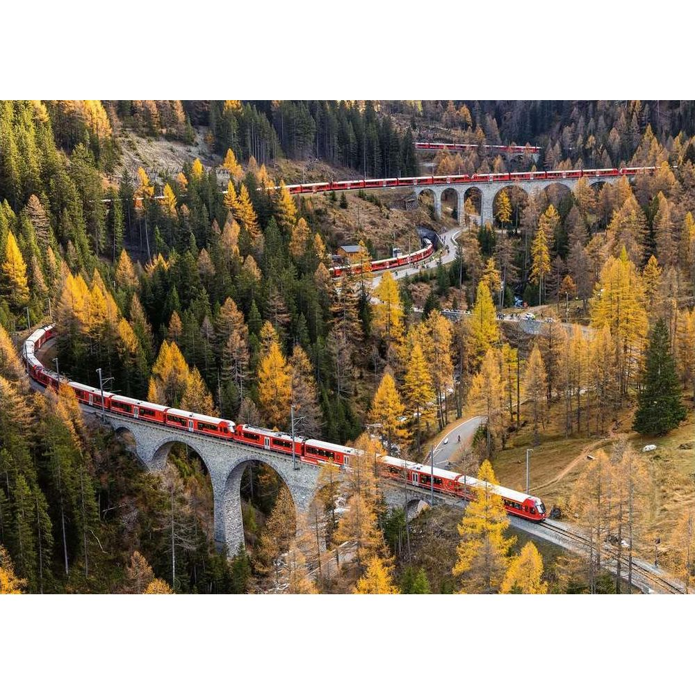 Un train rouge traverse un pont en arc de pierre à travers une forêt d'automne.