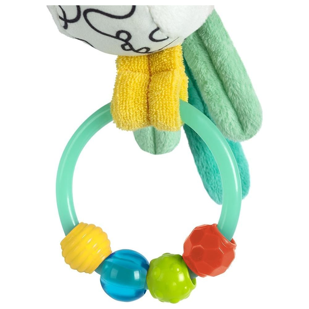 Un hochet en peluche avec des perles colorées sur un anneau vert.