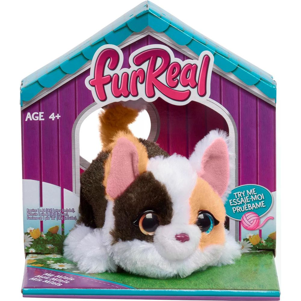 Un chaton en peluche FurReal avec des taches brunes, blanches et oranges dans une boîte à jouets.