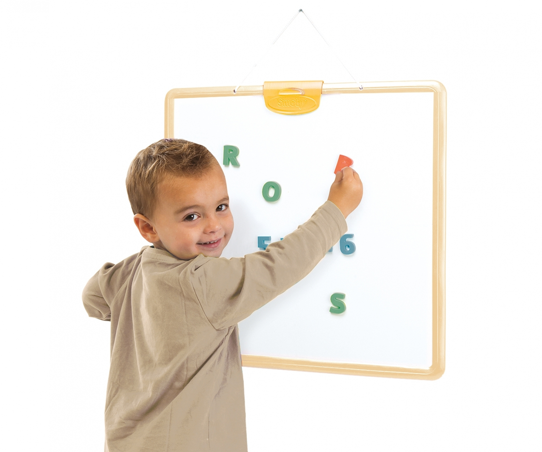 Ein Junge mit braunem Hemd setzt einen roten Buchstaben auf ein Whiteboard.