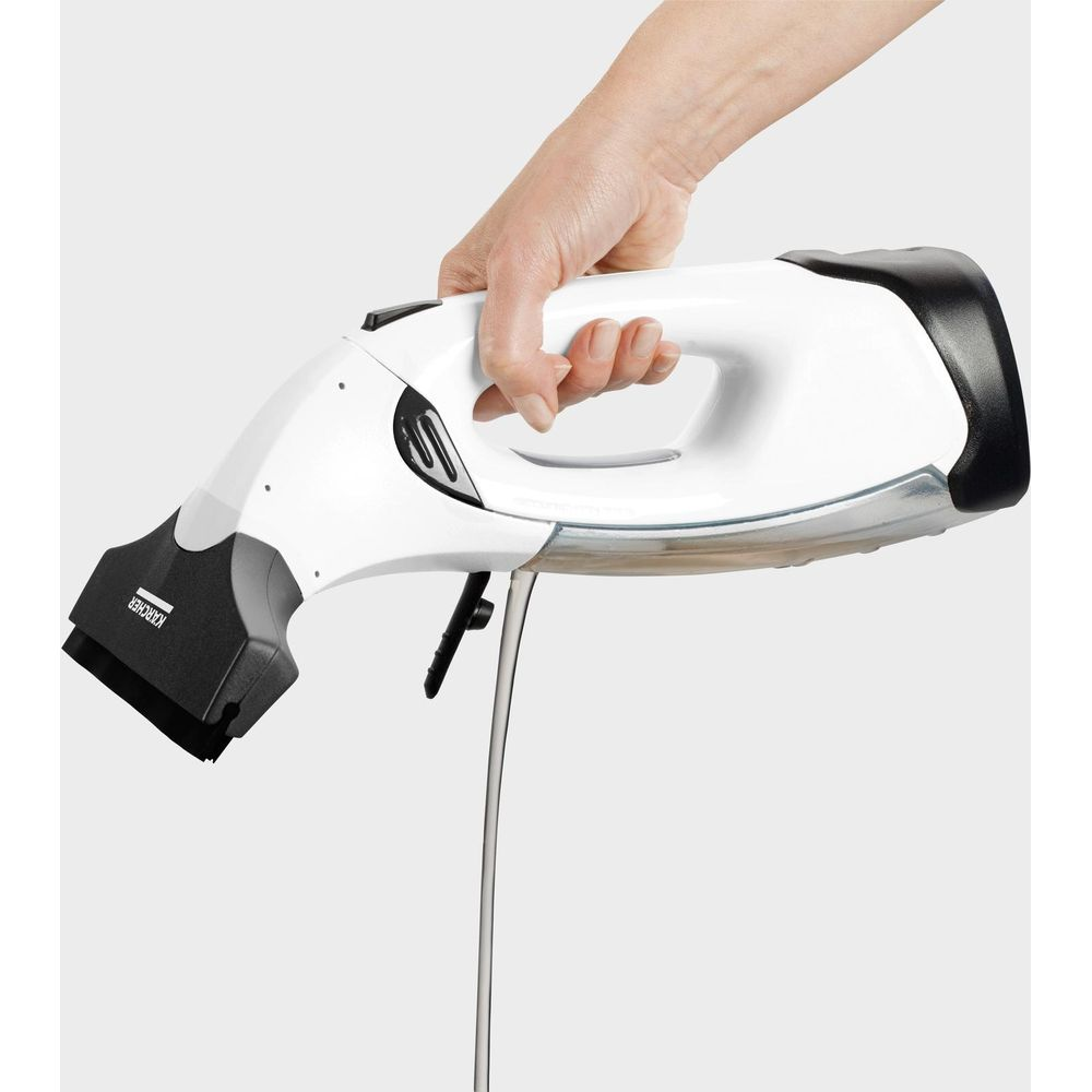 Una mano tiene un pulitore per vetri bianco con manico nero e lama in gomma.