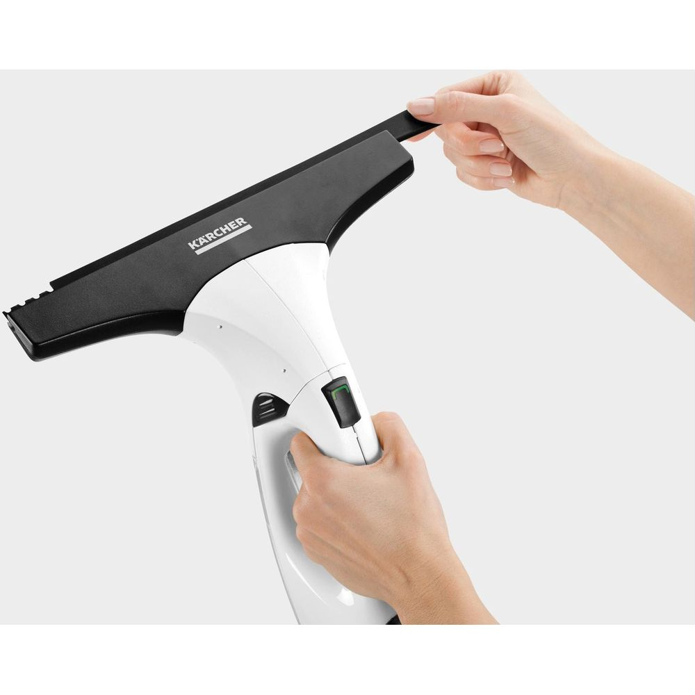Una mano tiene un aspiravetri bianco con accessorio nero; un'altra mano tocca l'accessorio.