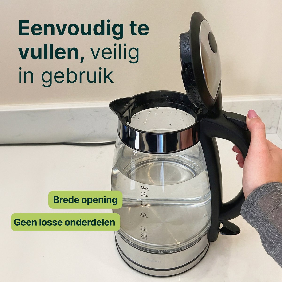 A clear glass kettle with its lid open, filled with water.