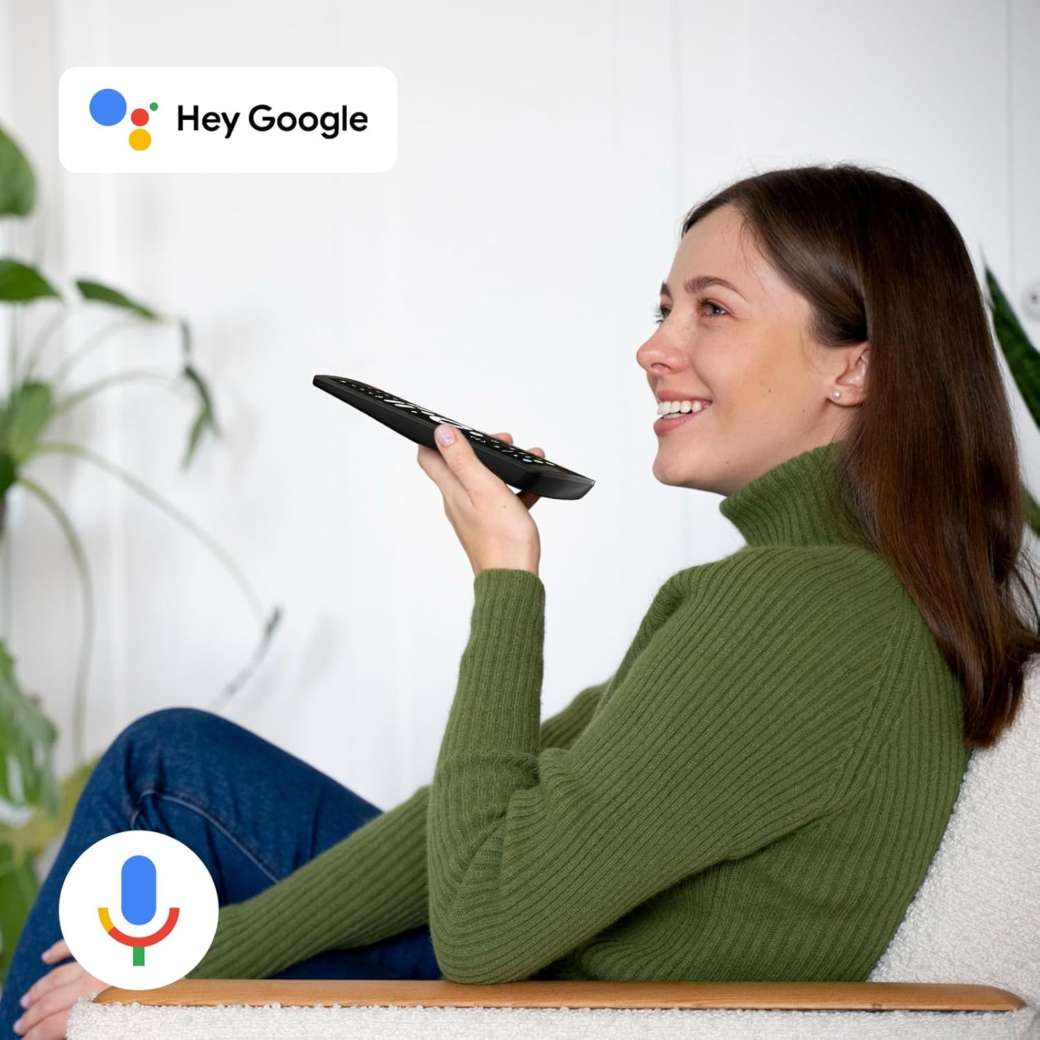 Frau mit Fernbedienung spricht mit Google Assistant.