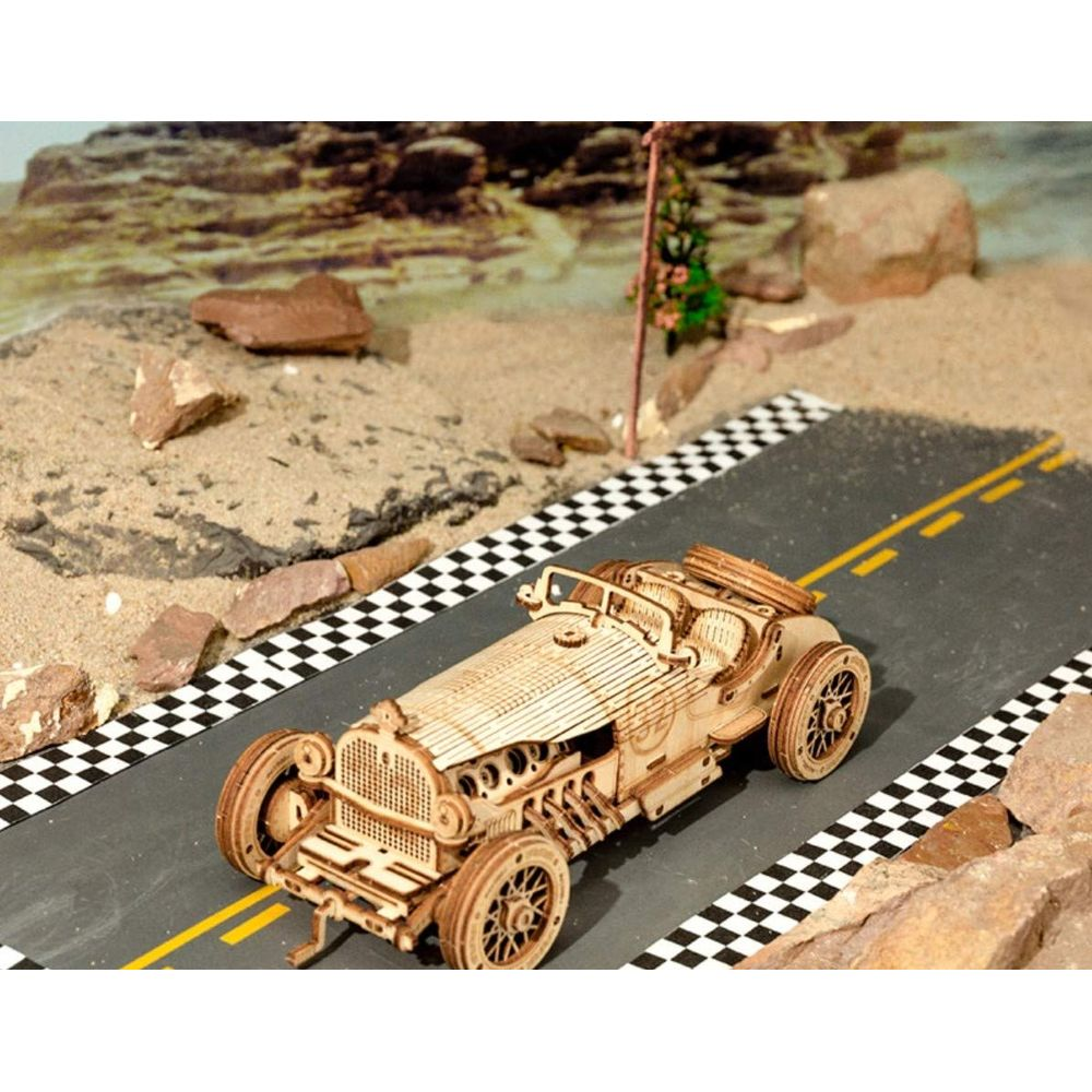 Ein Holzmodell eines Oldtimer-Rennwagens auf einer Rennstrecke.