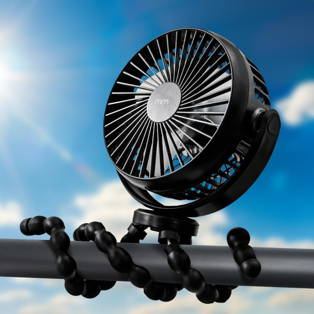 A black fan with flexible legs is perched on a pole outdoors.