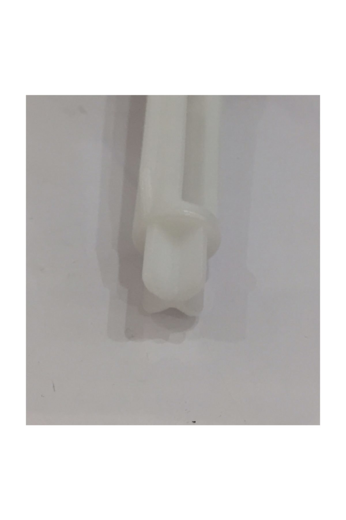 Altta iki yuvası olan beyaz plastik adaptörün yakın çekimi.