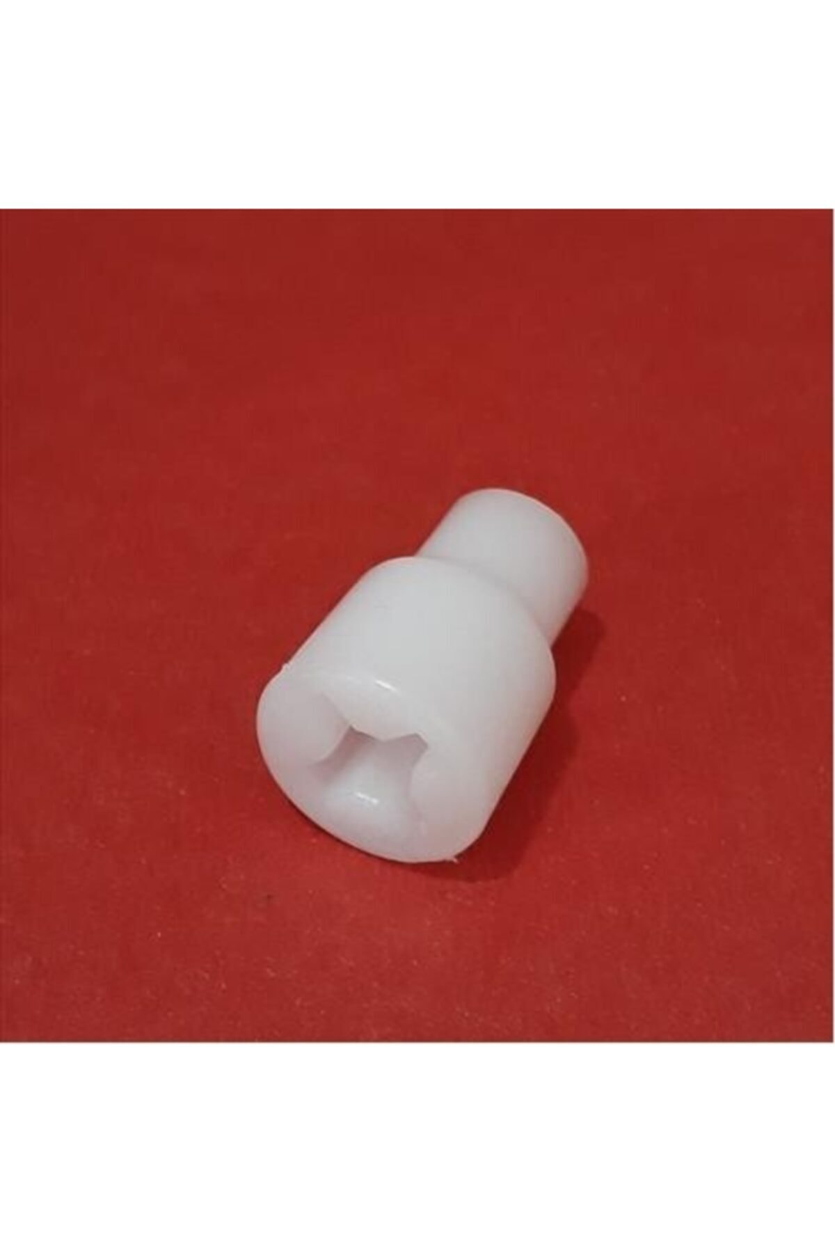 Kırmızı arka plan üzerinde altıgen delikli beyaz plastik adaptör.