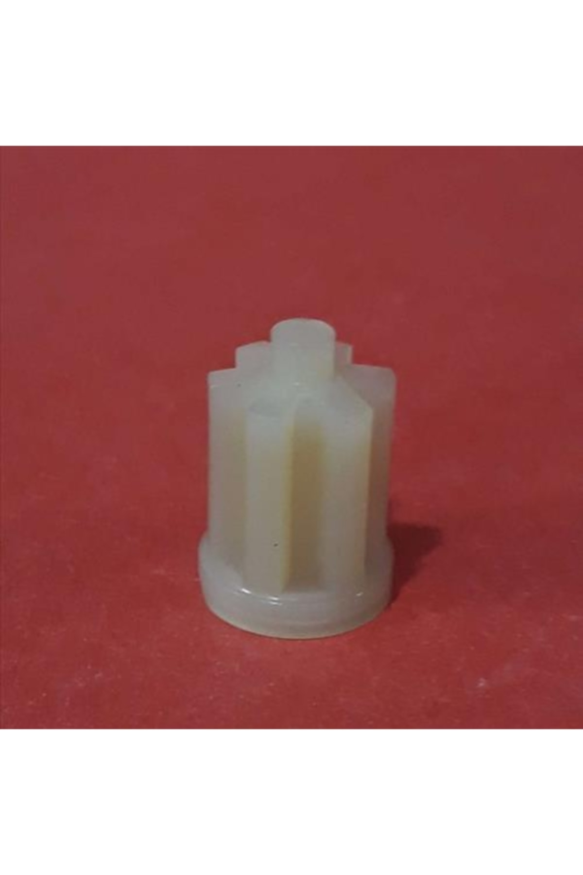 Kırmızı arka plan üzerinde beyaz plastik dişli.