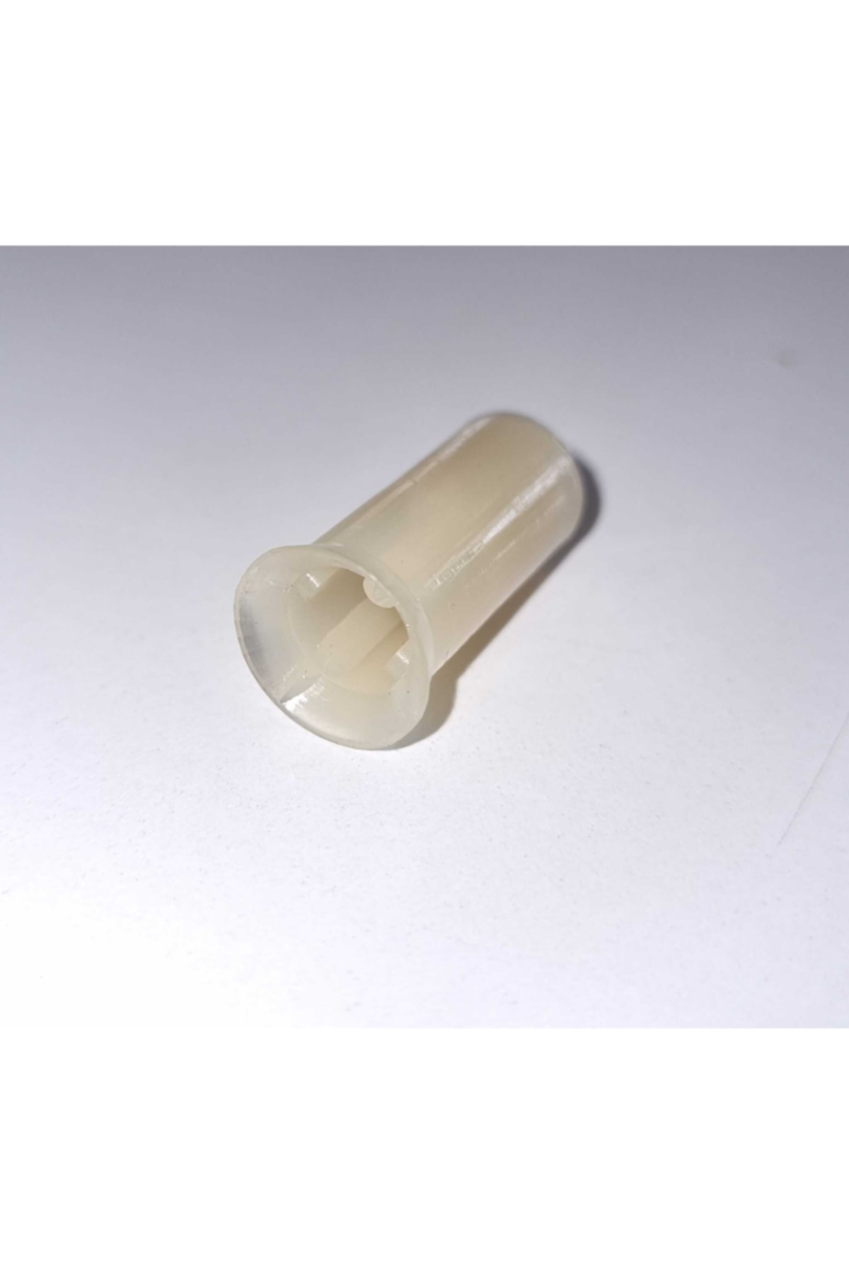 Açılı uçlu ve iç oluklu açık bej plastik parça.