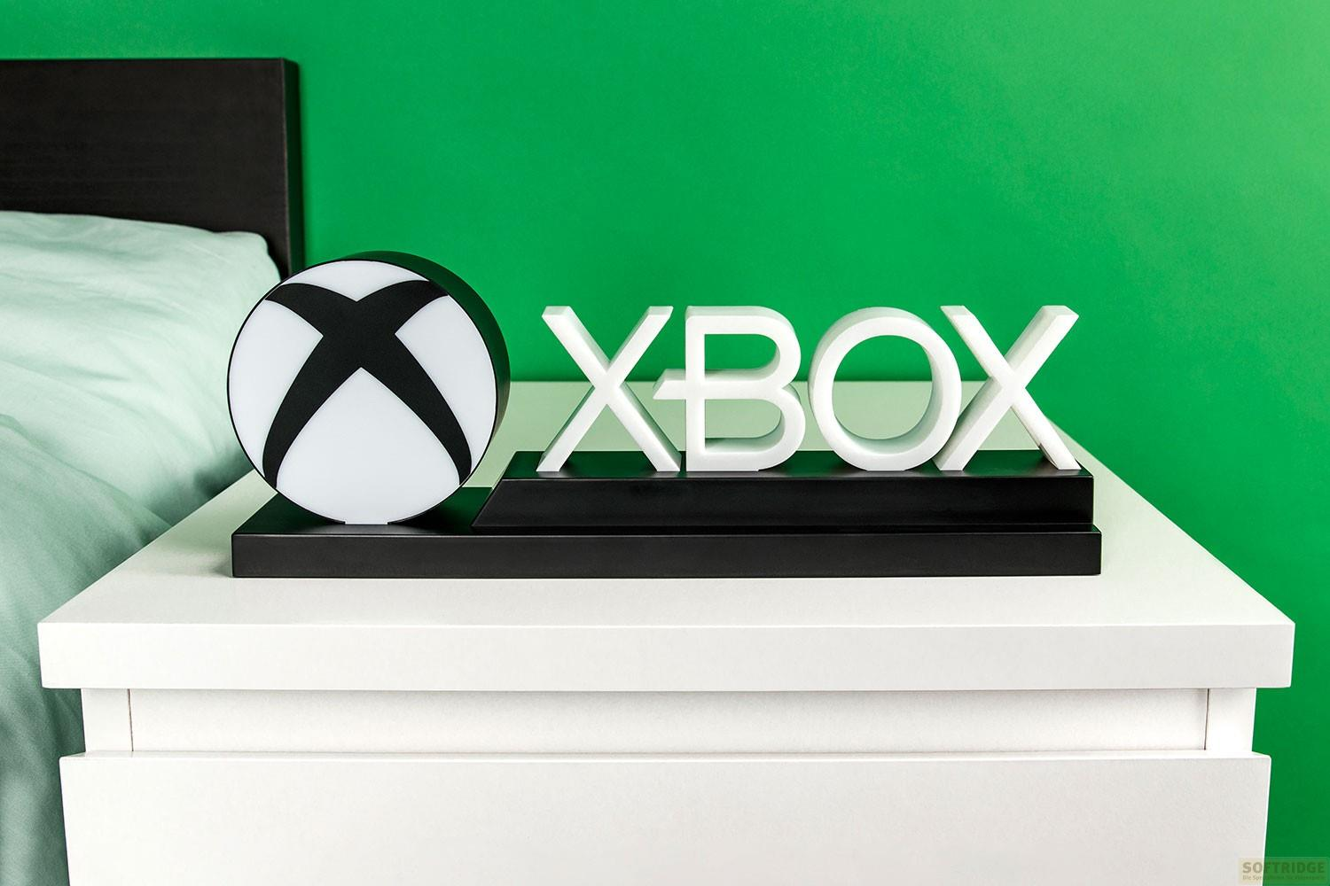 Xbox-Logo und Schriftzug auf weißem Nachttisch vor grünem Hintergrund.