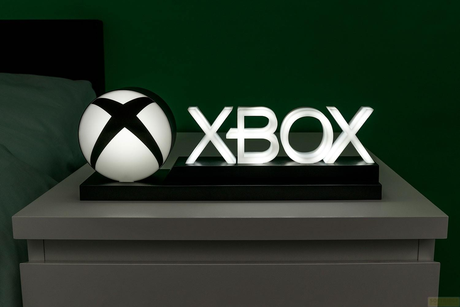 Xbox-Logo-Lampe mit Ball auf Nachttisch, grüner Hintergrund.