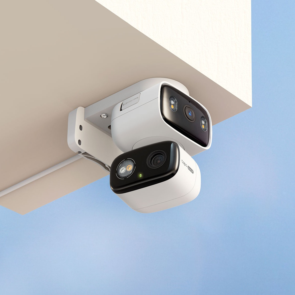 Dwie białe kamery bezpieczeństwa z czarnym przodem są zamontowane na suficie.