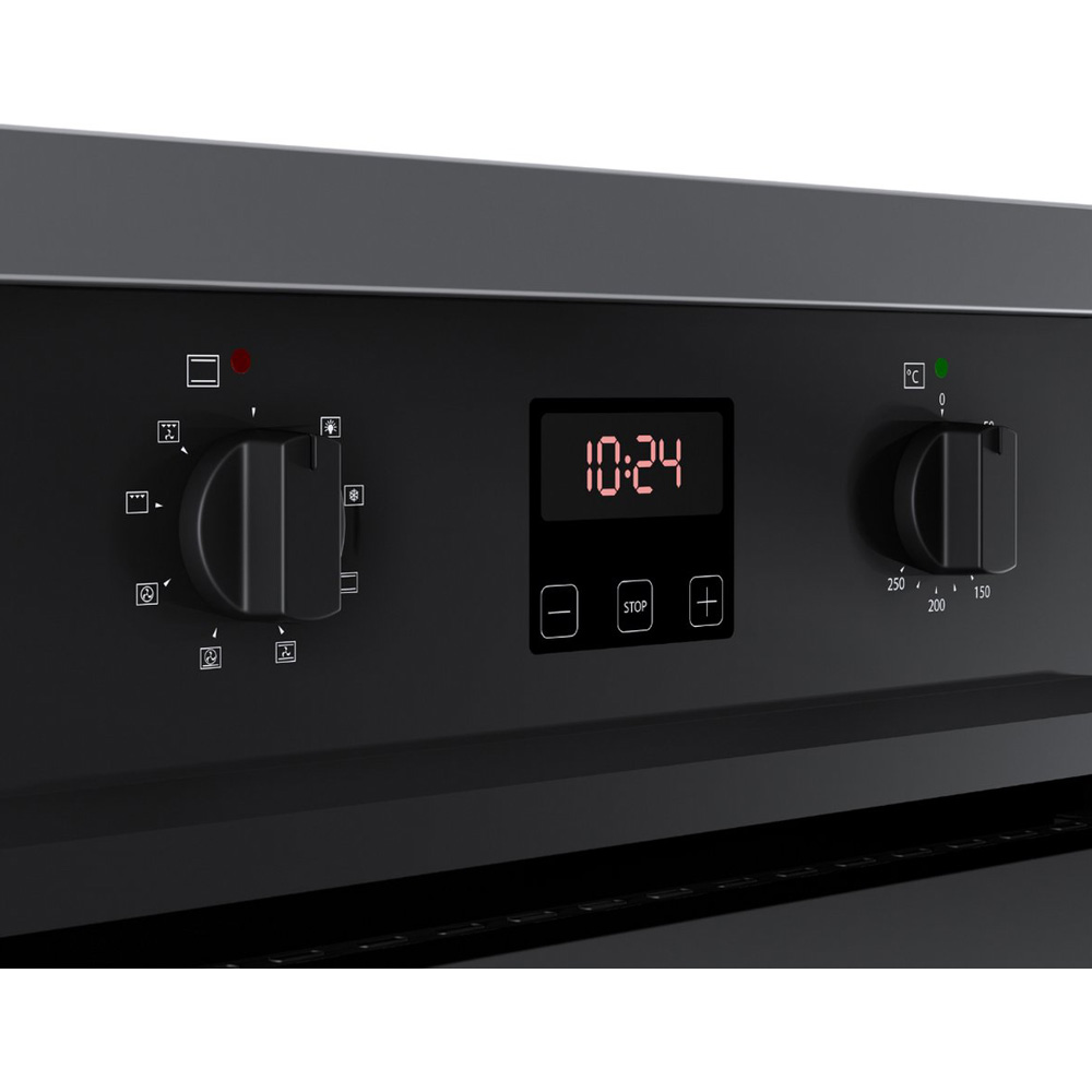 Close-up of a black oven with a digital clock display (10:24) and control knobs.