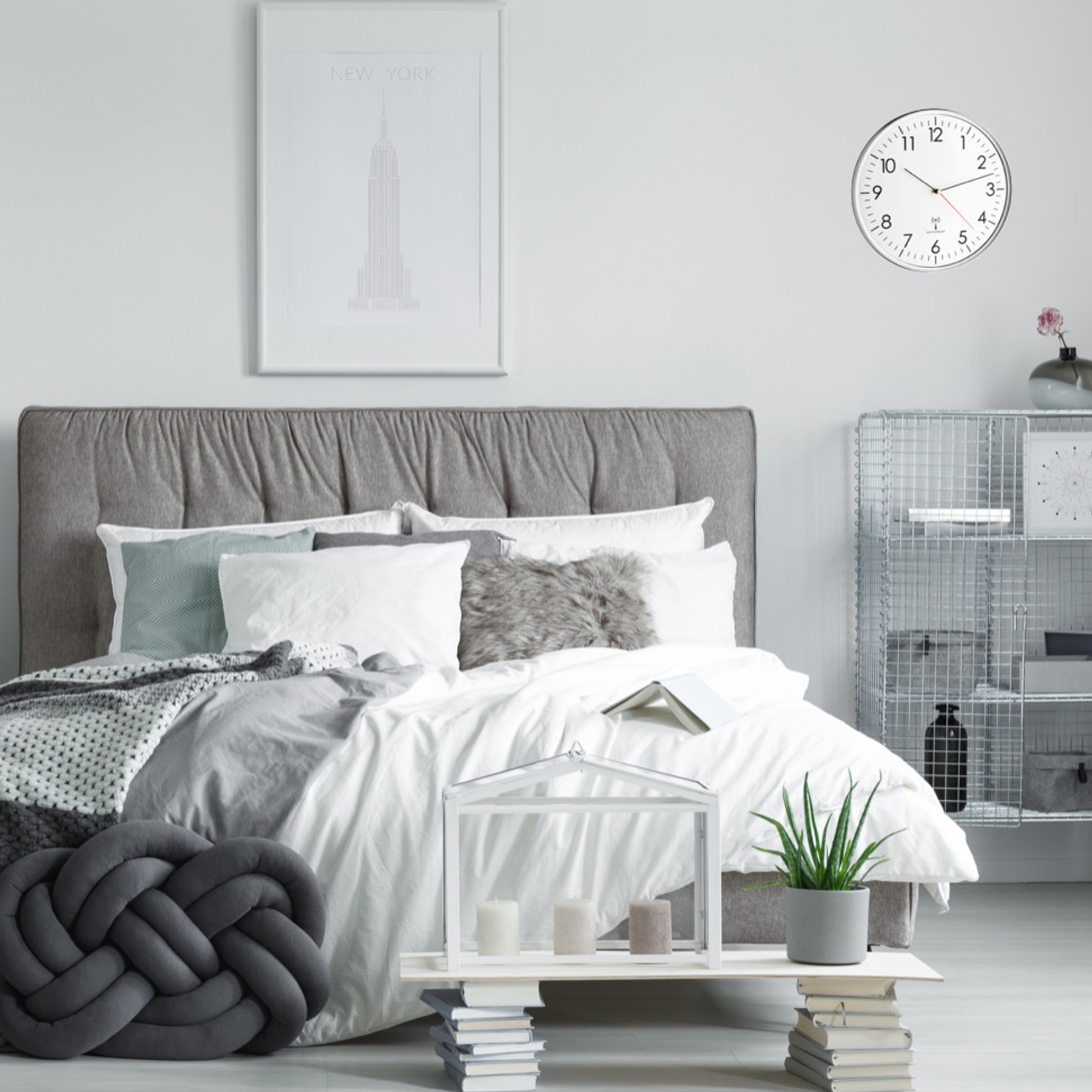 Nowoczesna sypialnia z dużym łóżkiem, dekoracjami i półką.