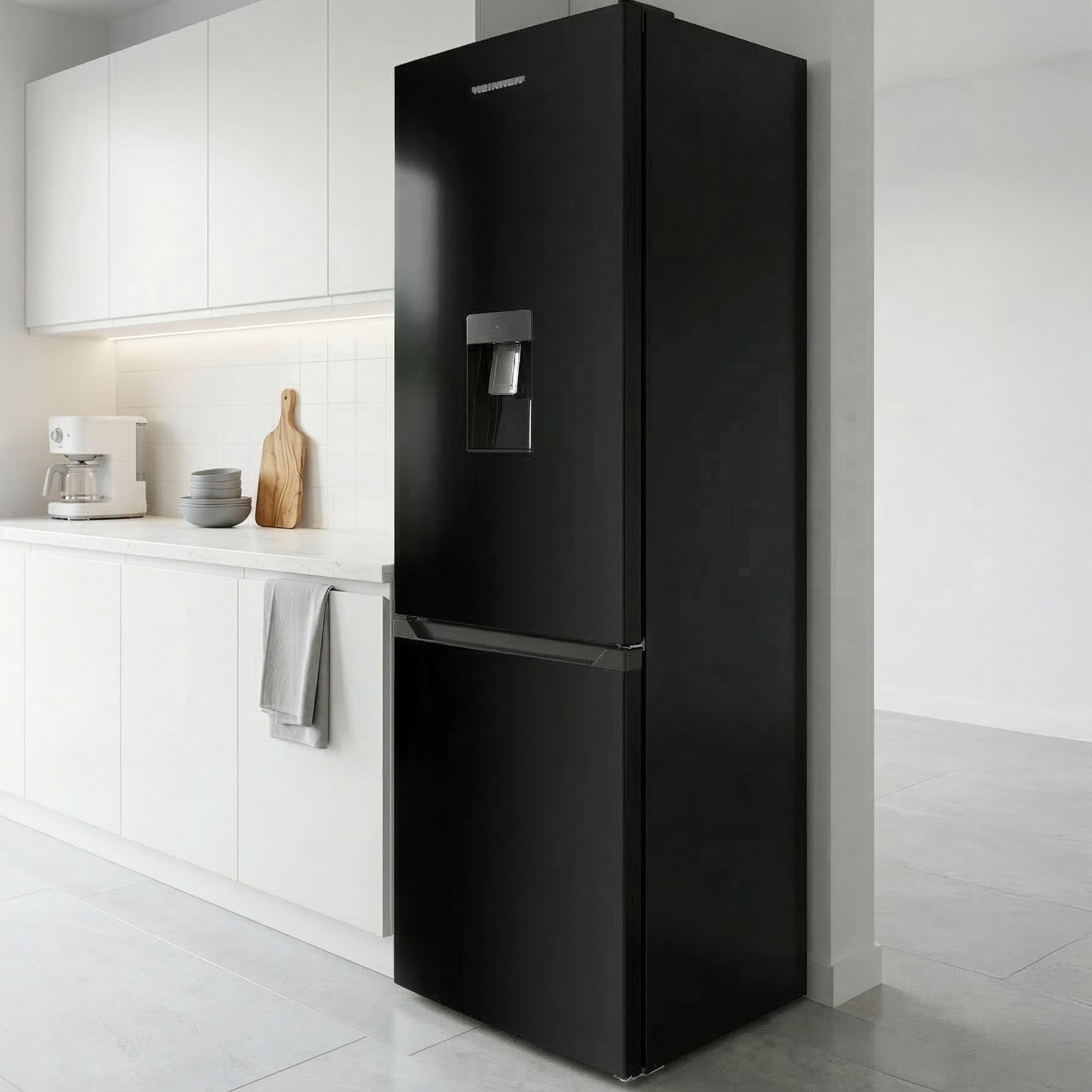Schwarzer Kühlschrank mit Wasserspender neben weißen Küchenschränken mit Geräten.