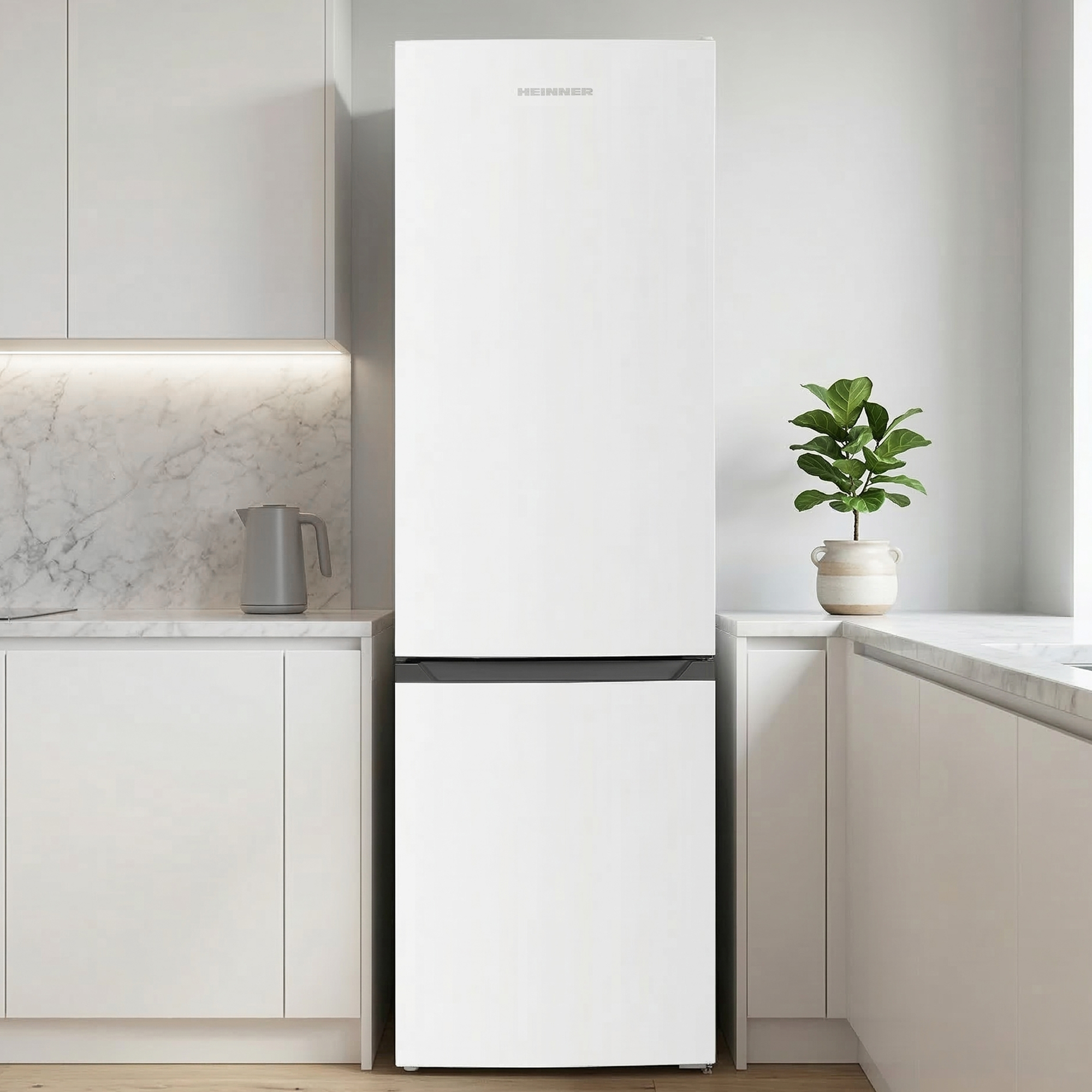 Een witte koelkast staat in een moderne keuken naast een aanrecht met een potplant.