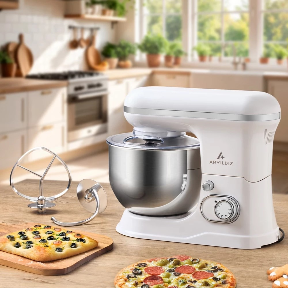 Ahşap masa üzerinde pizzalar ve aparatlarla duran beyaz stand mikser.