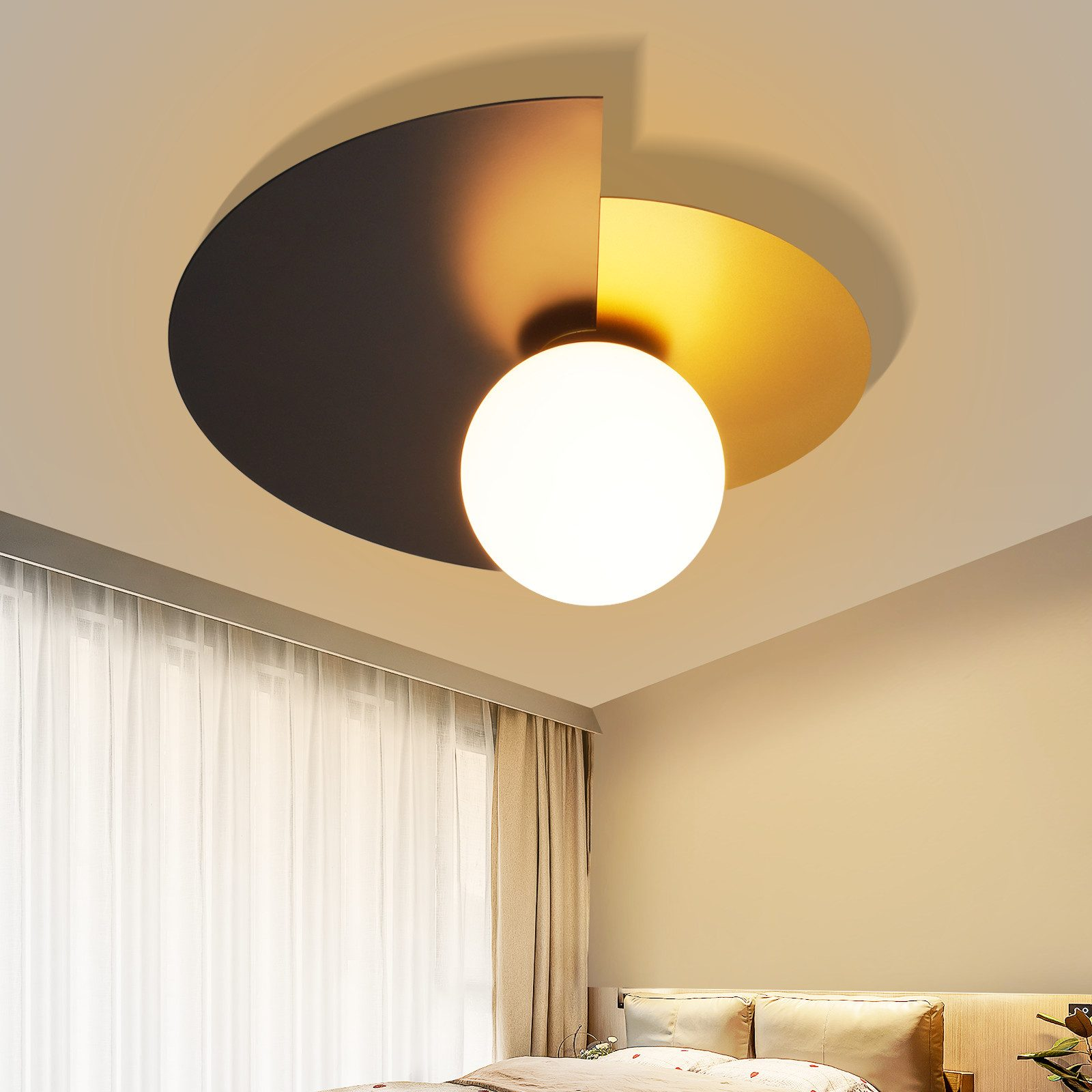 Lampada da soffitto moderna con segmenti dorati e scuri e una sfera di vetro bianca.