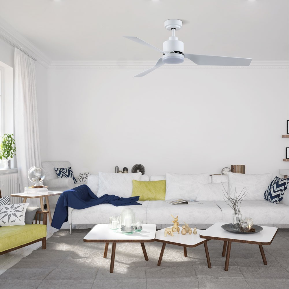 Un ventilador de techo blanco sobre una sala de estar moderna con sofá blanco y cojines.