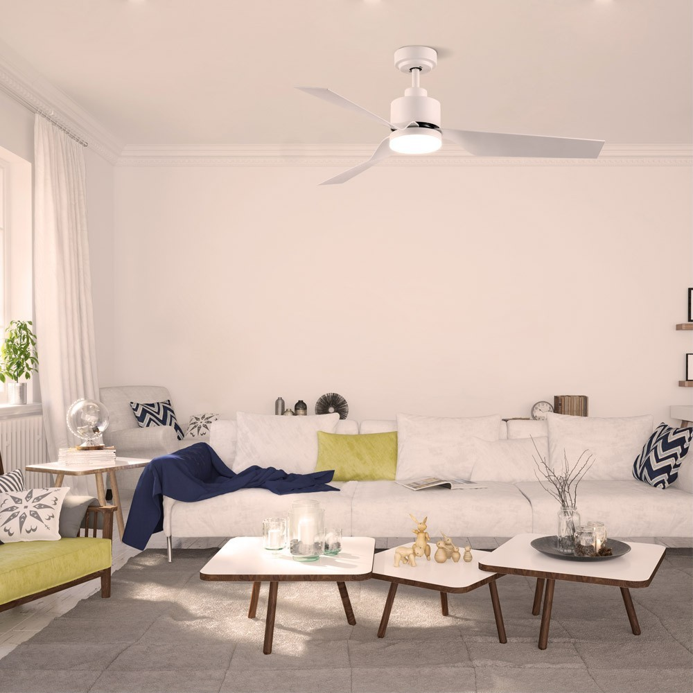 Una sala de estar luminosa con sofá blanco, mesas de centro y ventilador de techo.