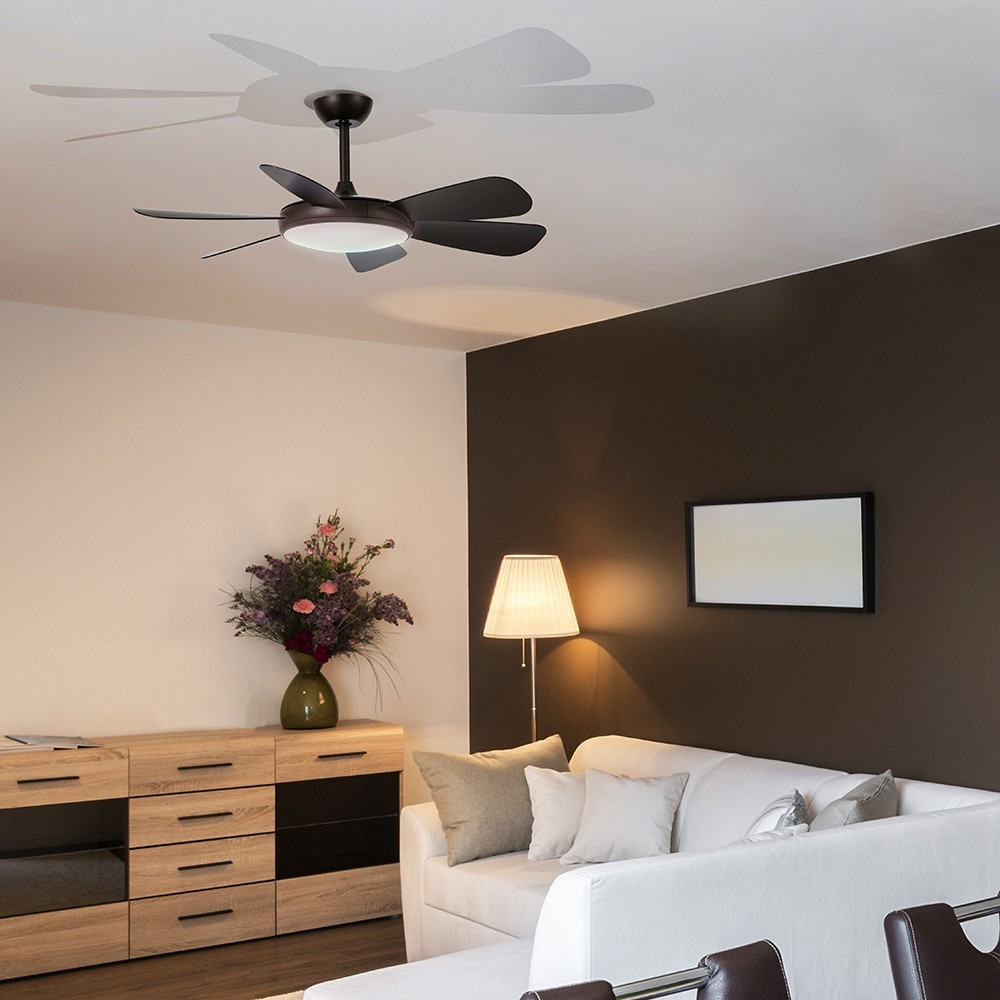 Ventilador de techo oscuro con luz sobre un sofá y un aparador. Sala moderna.