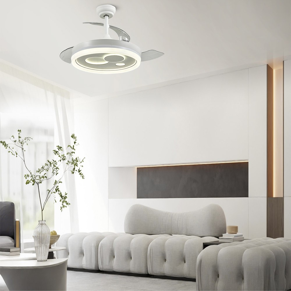 Un ventilador de techo moderno con luz sobre un sofá blanco.