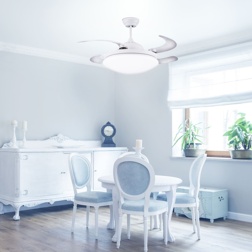 Un ventilador de techo blanco con luz sobre una mesa y sillas de comedor.