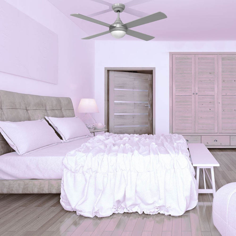 Un dormitorio rosa con cama, armario y ventilador de techo.