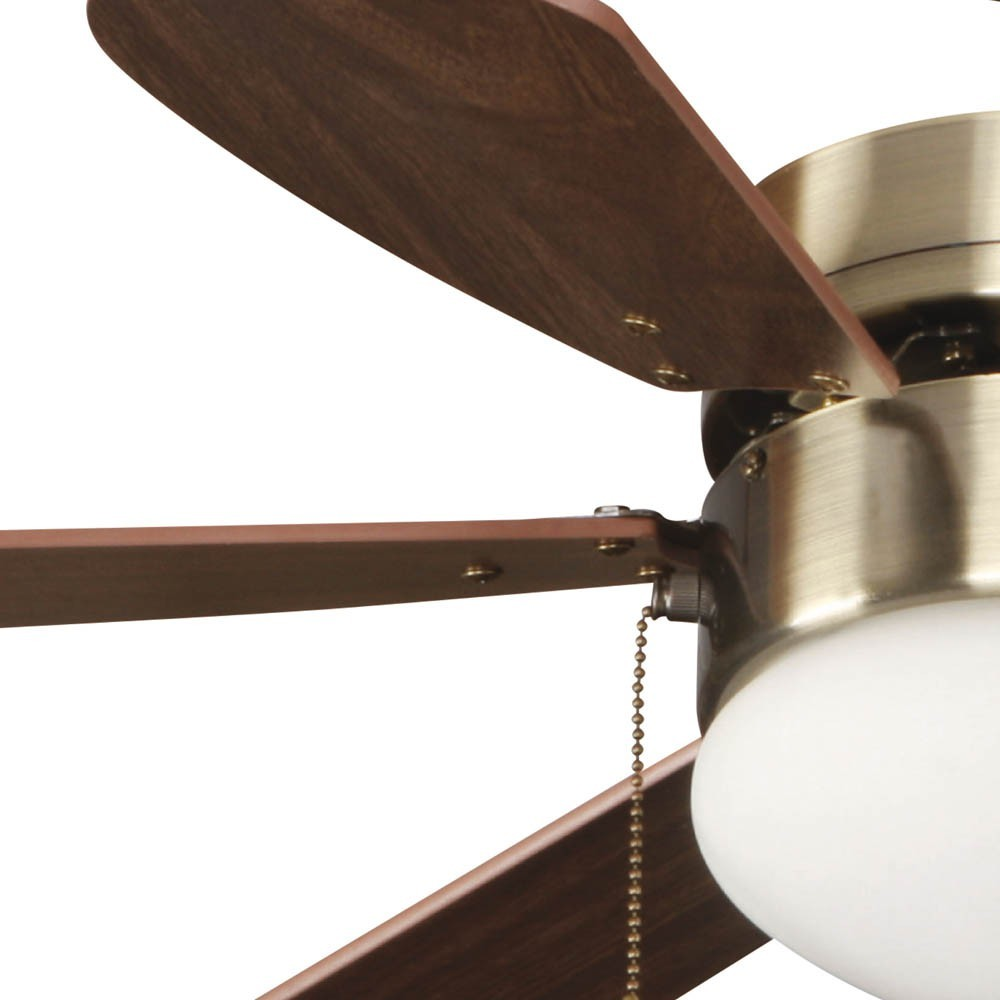 Ventilador de techo con aspas de madera, carcasa de latón y luz blanca.
