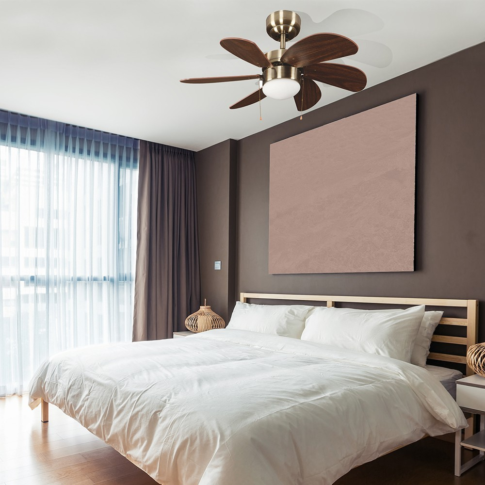 Un dormitorio con cama, ventilador de techo y cuadro.