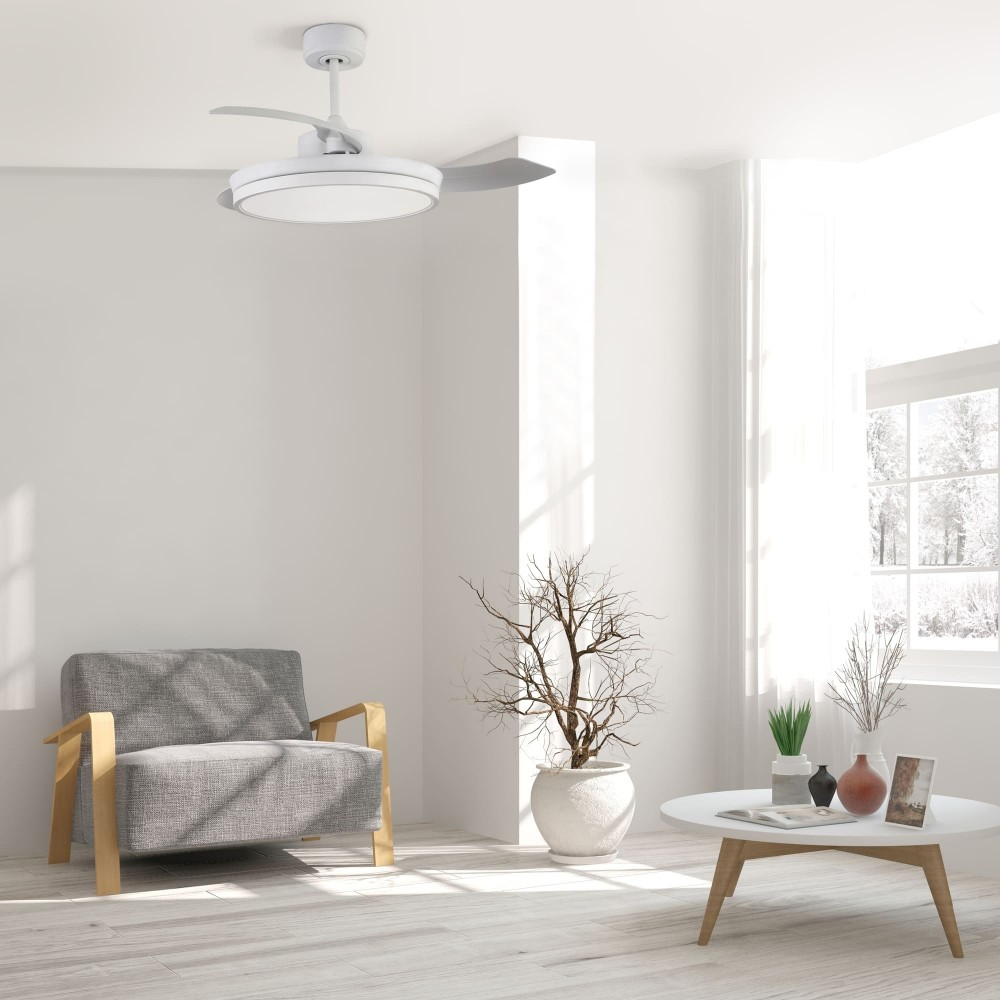 Una sala moderna con sillón gris, mesa blanca y ventilador de techo. Nieve afuera.