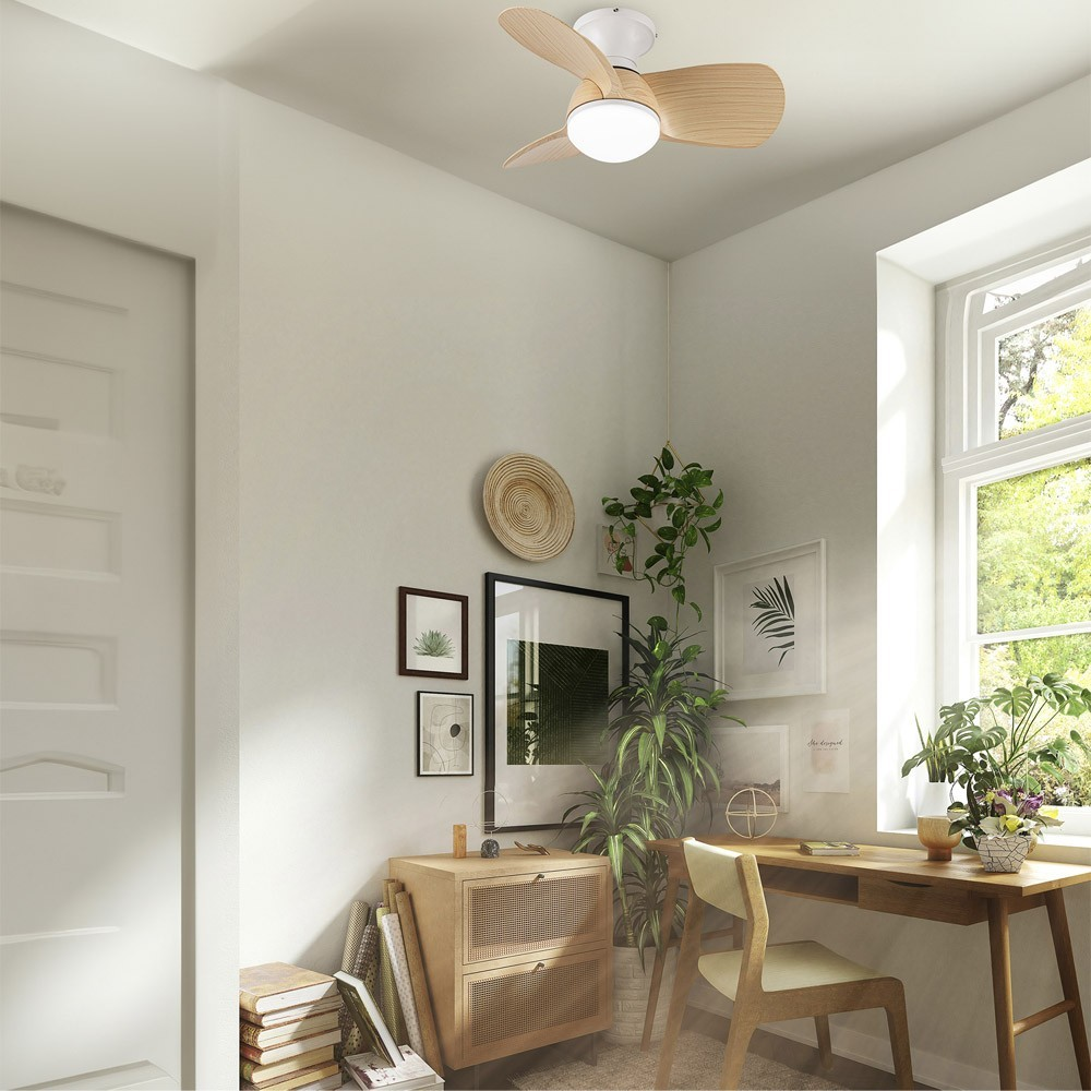 Un ventilador de techo de madera sobre un escritorio con plantas y arte en la pared.