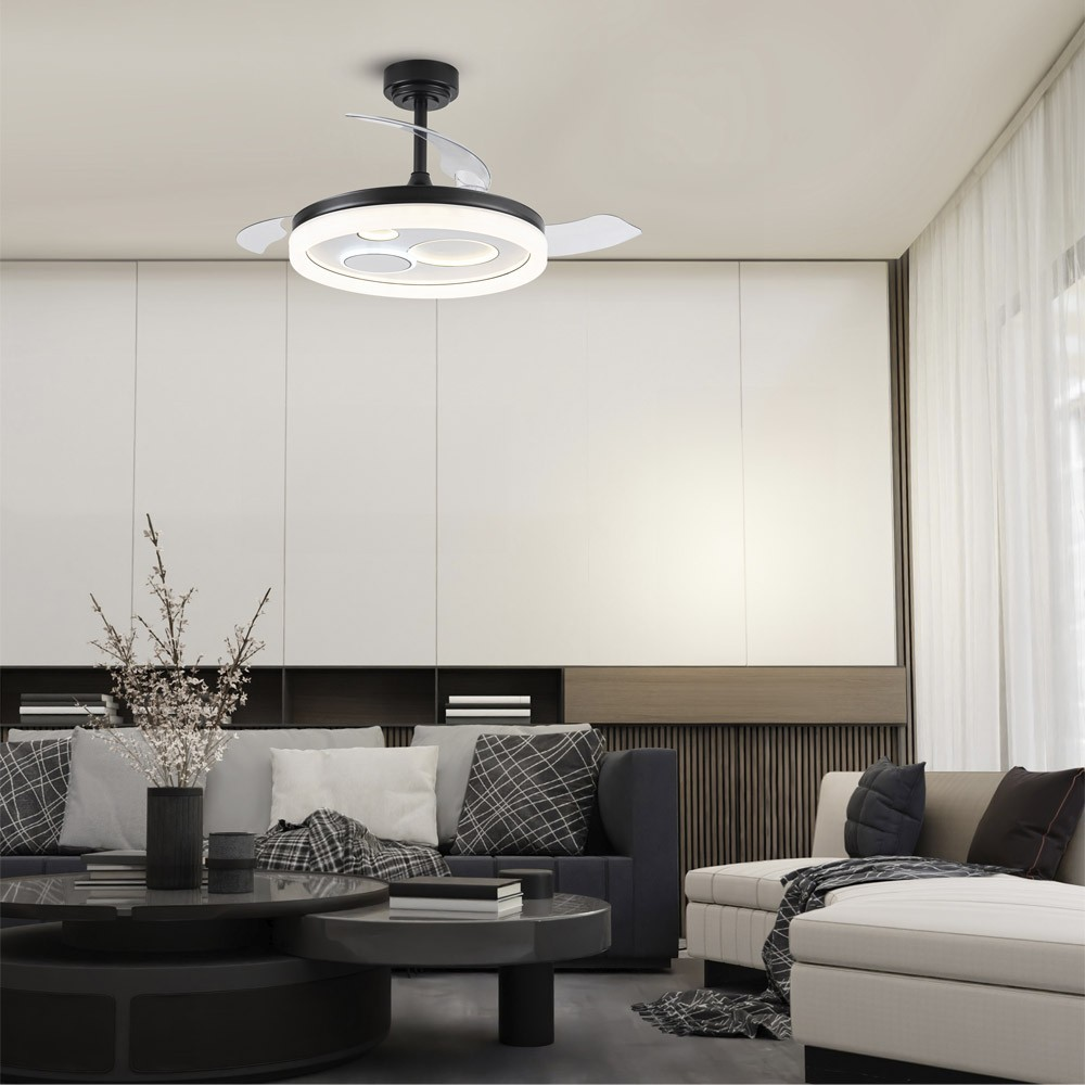 Un ventilador de techo moderno con luz sobre un sofá oscuro.