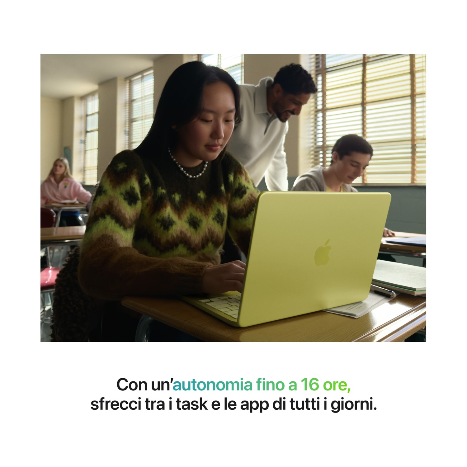 Uczniowie pracują na laptopach w klasie. Nauczyciel pomaga.