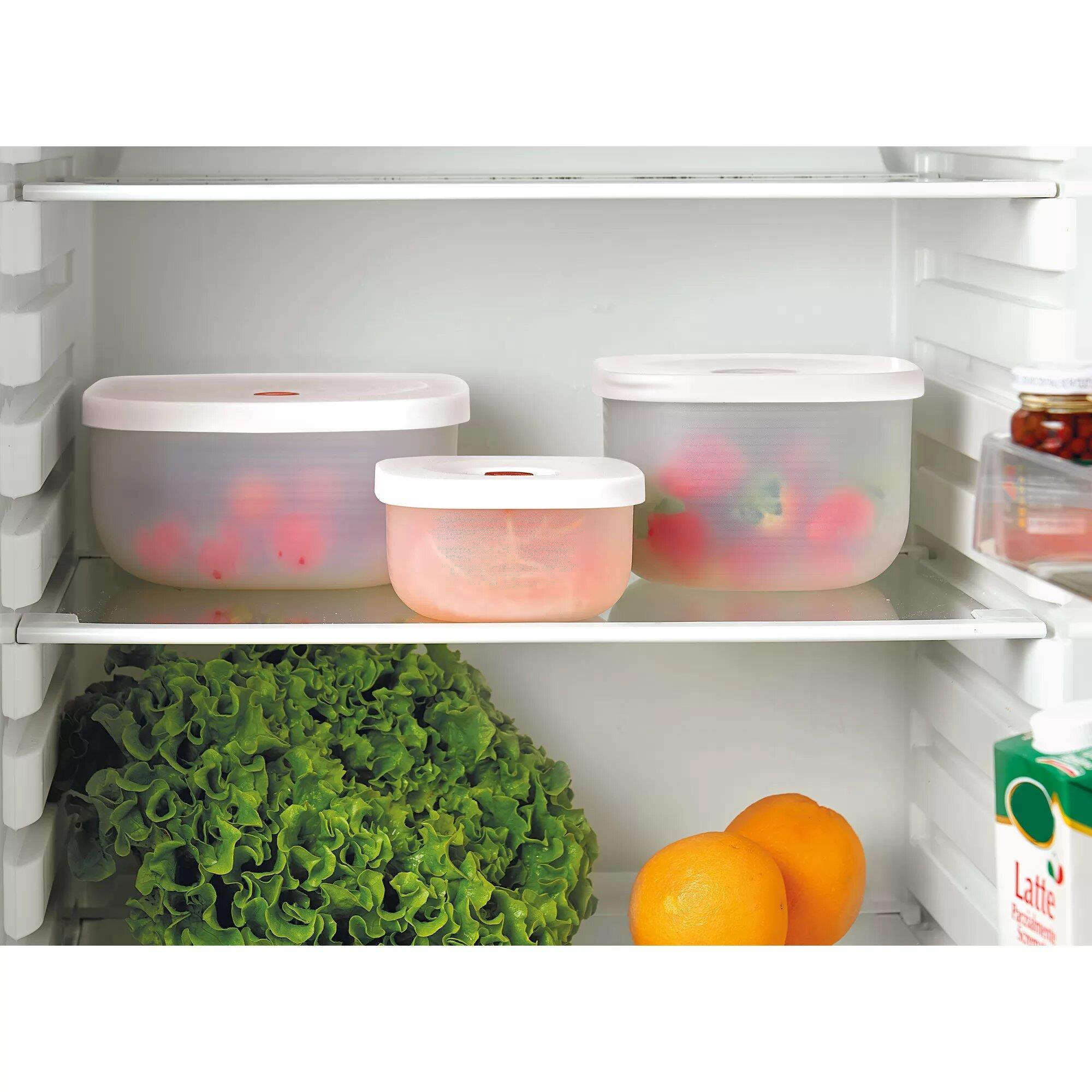 Estante de refrigerador con lechuga, naranjas, recipientes de fruta y un cartón de leche.