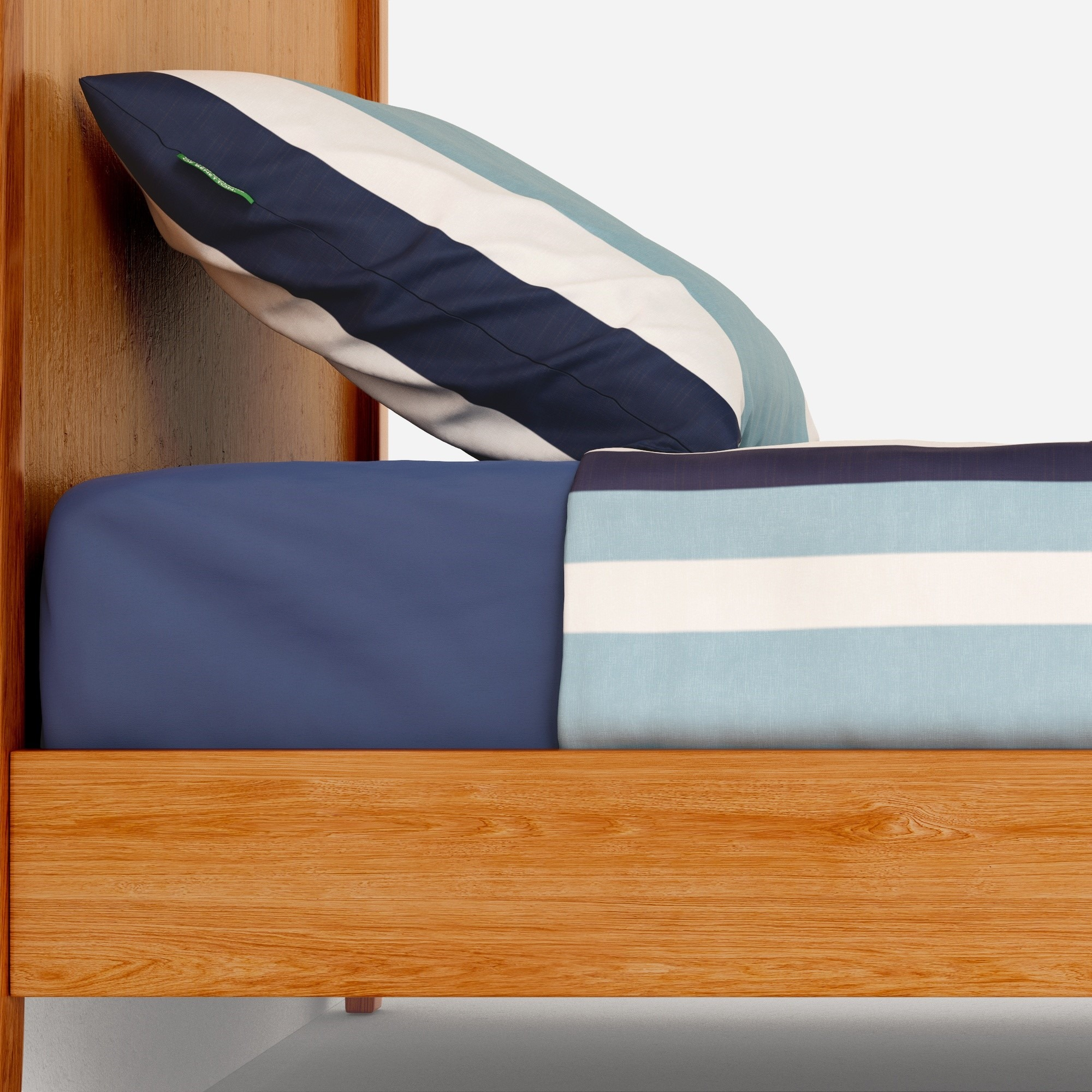 Una cama de madera con ropa de cama a rayas y una almohada azul.