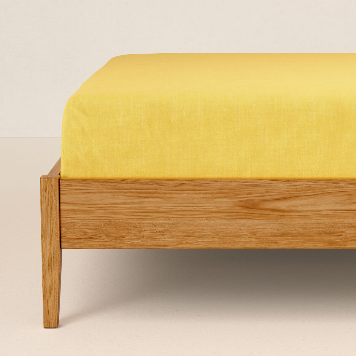 Una cama amarilla con marco de madera.