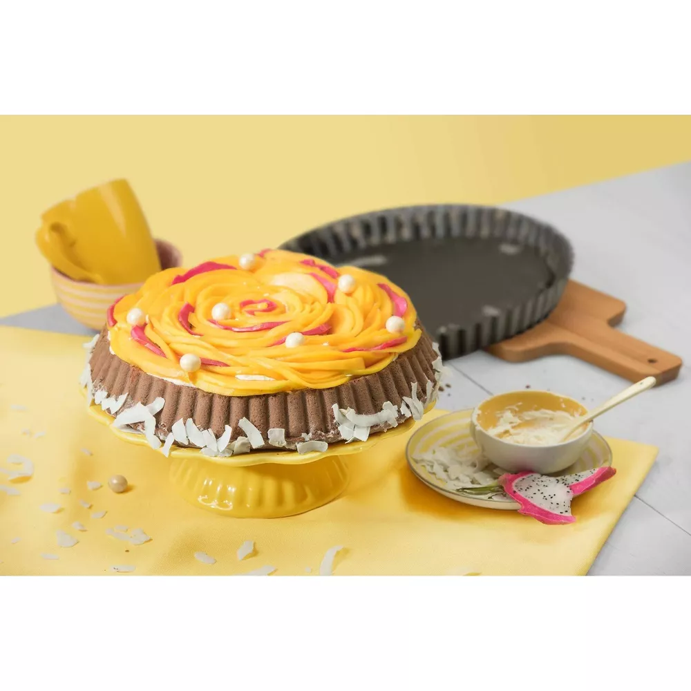 Ein Kuchen mit Schokoladenseite, Kokosraspeln und Mango-Topping.