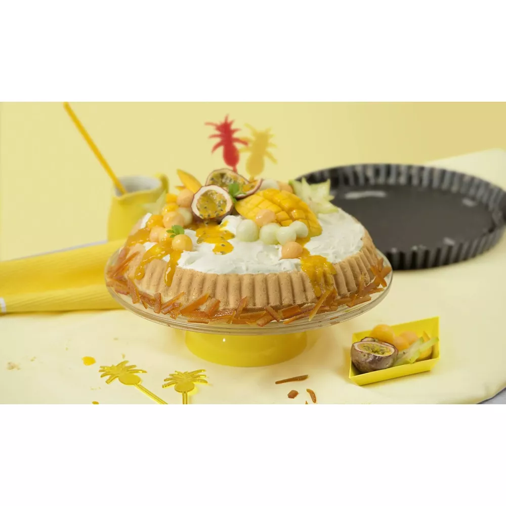 Ein tropischer Obstkuchen mit Sahne, Mango, Maracuja und Melonenbällchen.