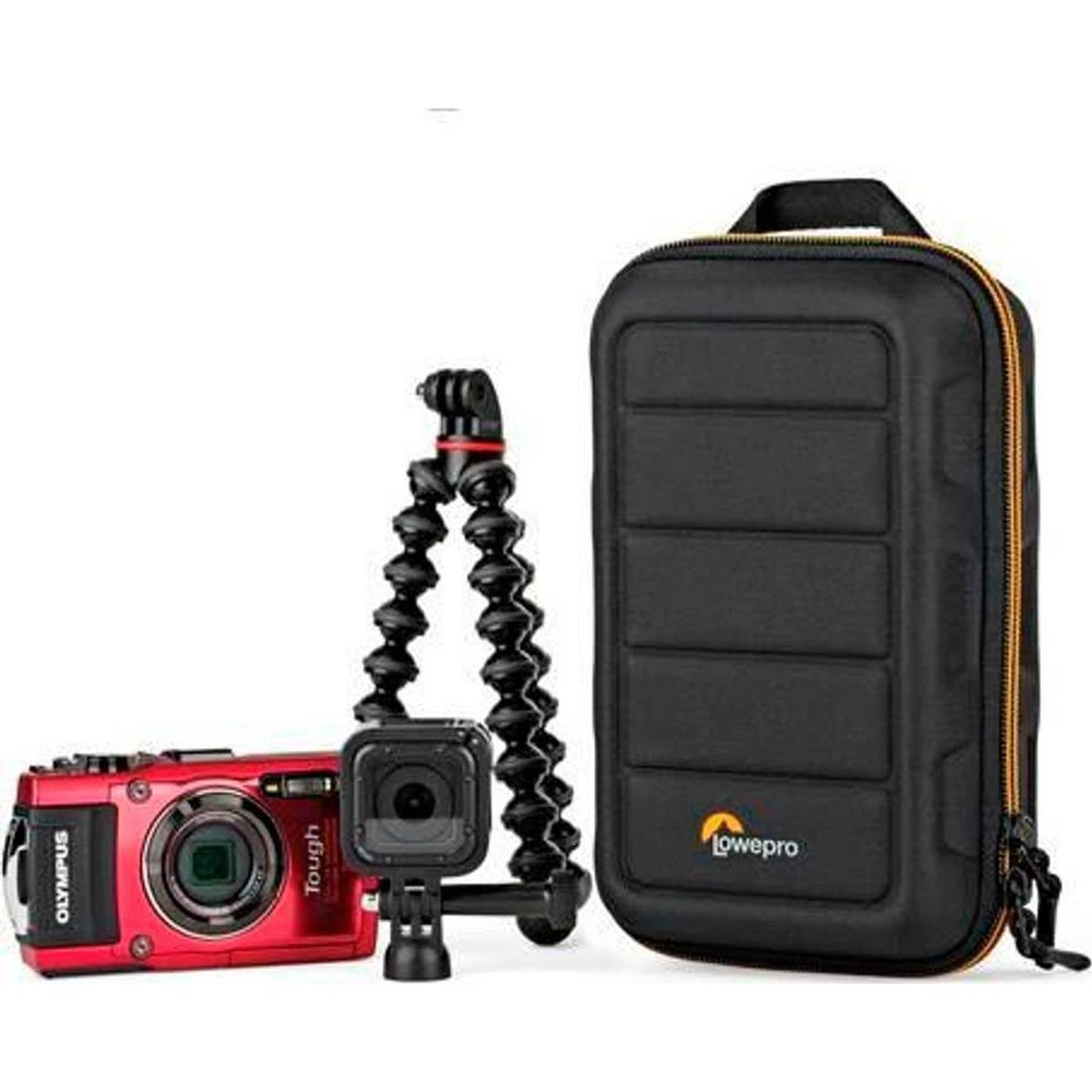 Una fotocamera Olympus rossa, una action cam e un Gorillapod accanto a una borsa nera.