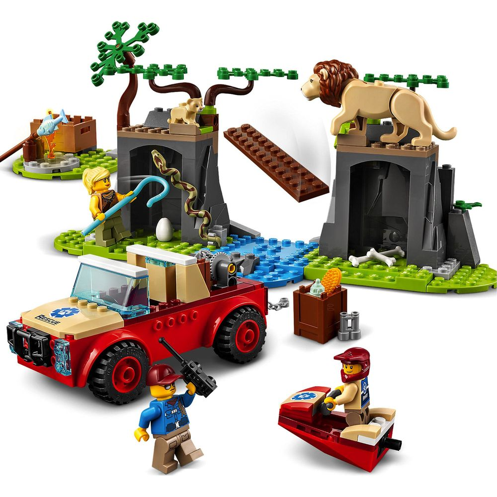Scène Lego avec lions, lionceau, serpent, camion de secours, bateau et figurines.