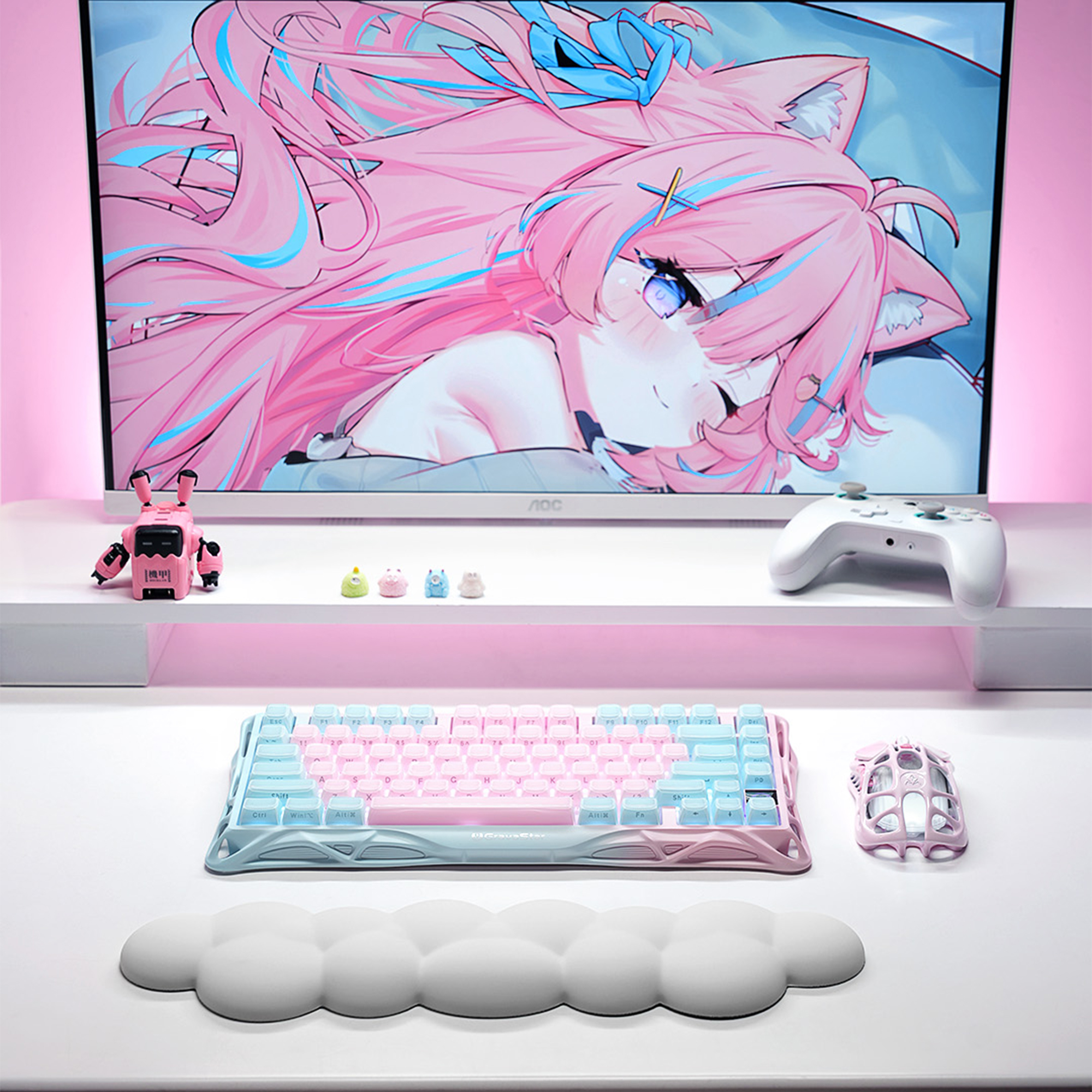 Ilustracja anime na monitorze nad klawiaturą, myszką i kontrolerem.