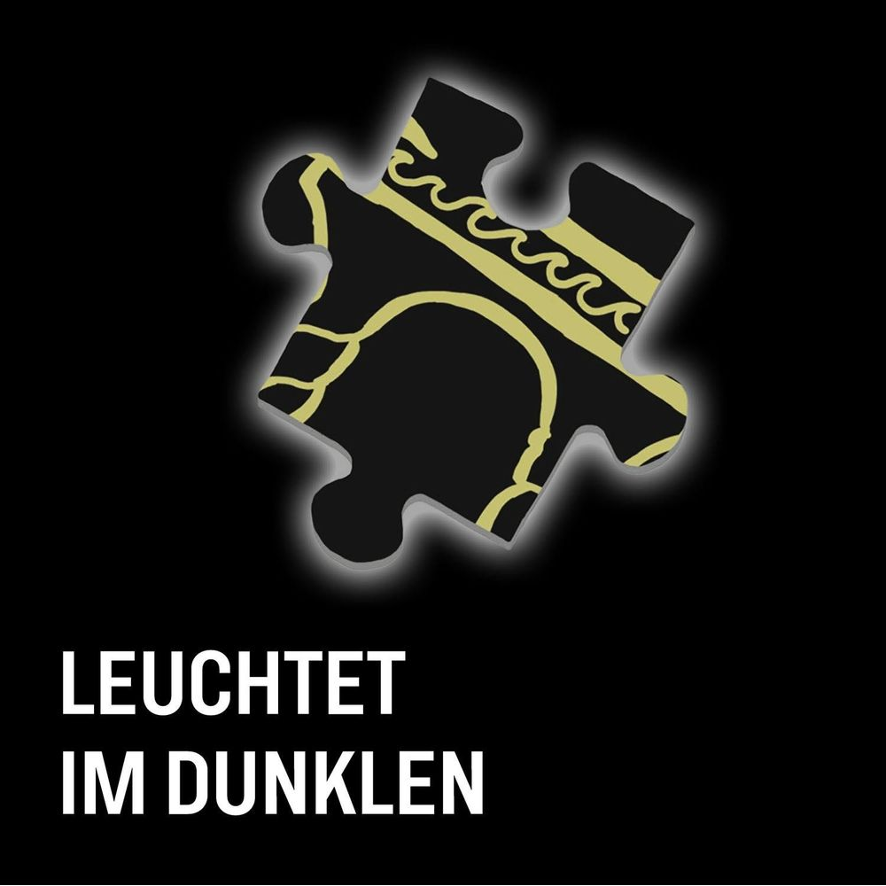 Ein schwarzes Puzzle-Teil mit goldenem Muster leuchtet im Dunkeln.