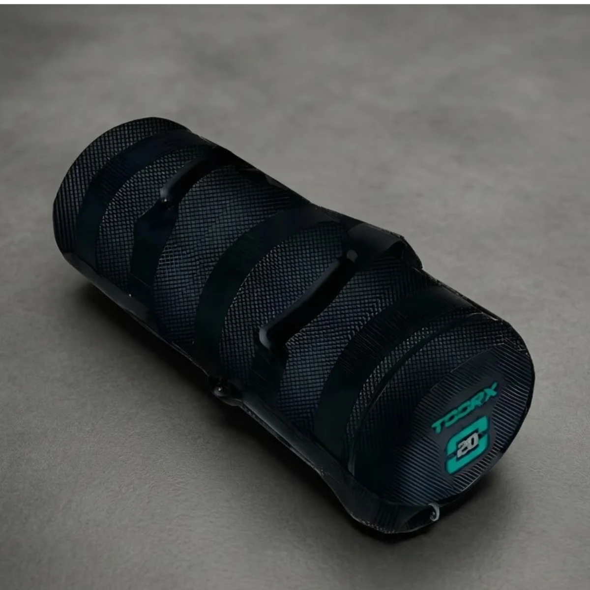 Black cylindrical object with textured grip and 'TDCRX 20' logo on a gray surface.